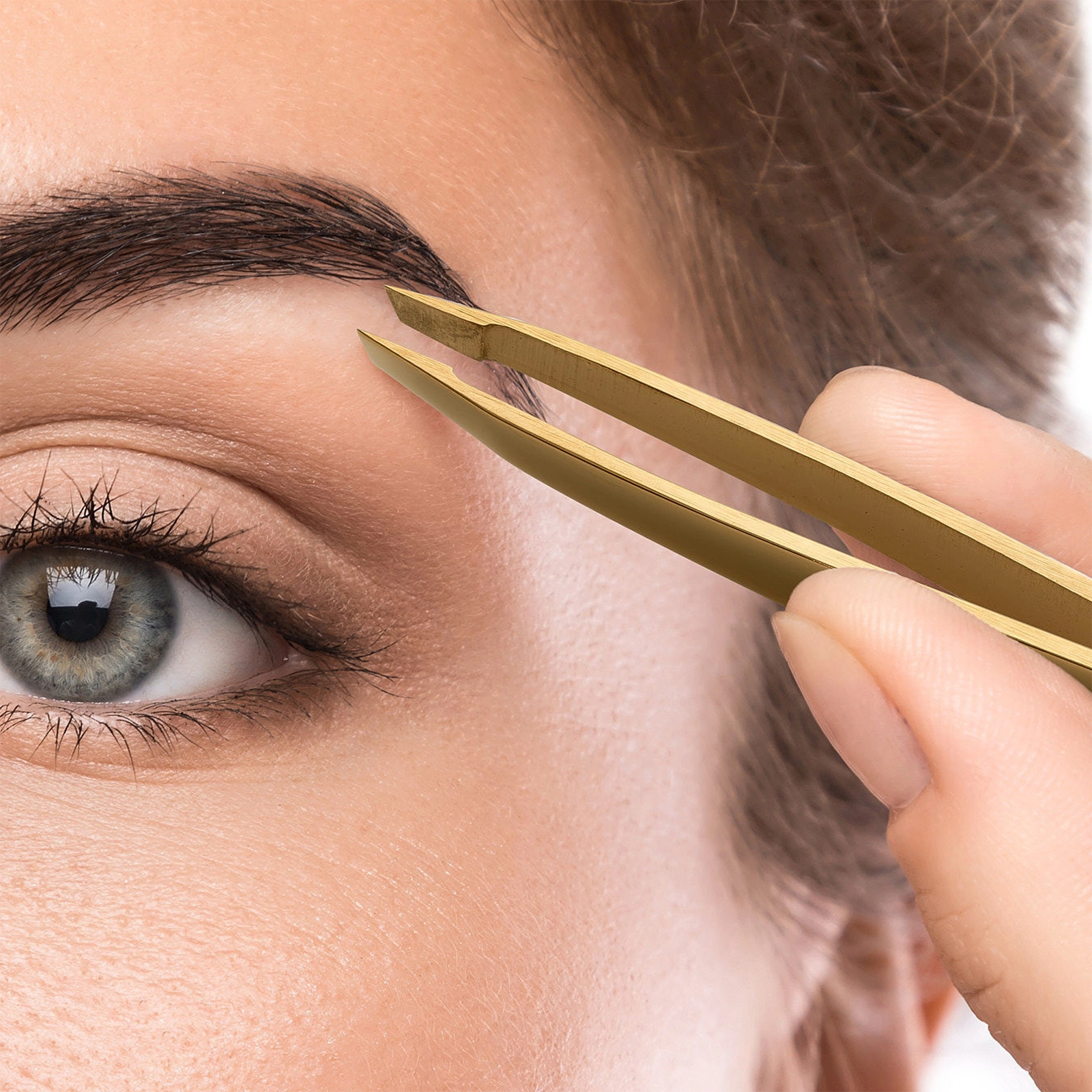 Gold slanted tweezers designed for precise eyebrow grooming and shaping.